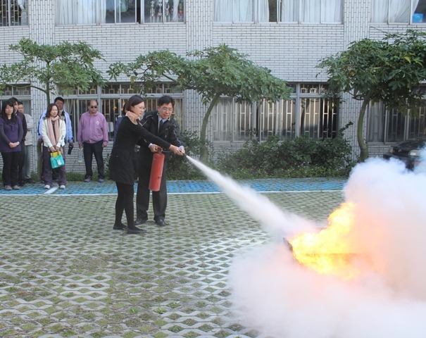 101.12.06 國立聯合大學秘書室許璧如小姐演練滅火器操作之照片圖片